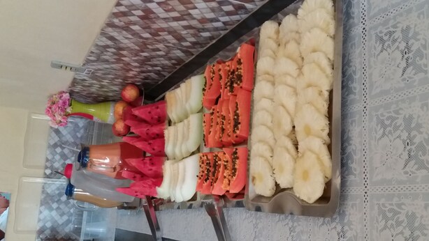 A fruit display with various types of fruits and a bottle of juice. - Pousada Veleiro de Porto (Ipojuca)