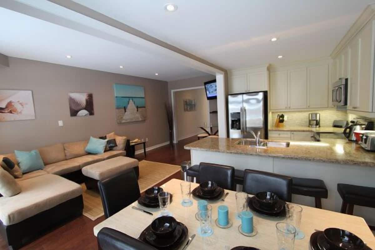 A modern kitchen with white cabinets, a built-in microwave, and a stainless steel refrigerator.