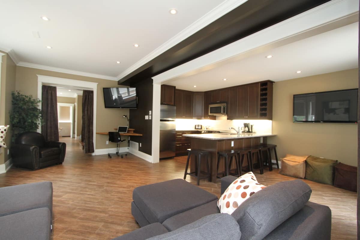 A modern living room with a gray sofa, a coffee table, and a TV mounted on the wall.