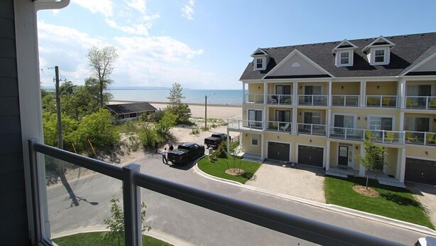 A multi-story hotel with a view of the beach. - Beachfront Beach Houses (Wasaga Beach)