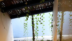 A wooden deck with a small table and chairs, surrounded by plants and a view of the sea. - Casa de Las Palomas by Palomas Hotels -  Adults only (Mérida)