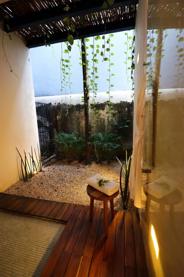 A wooden deck with a small table and chairs, surrounded by plants and a view of the sea. - Casa de Las Palomas by Palomas Hotels -  Adults only (Mérida)
