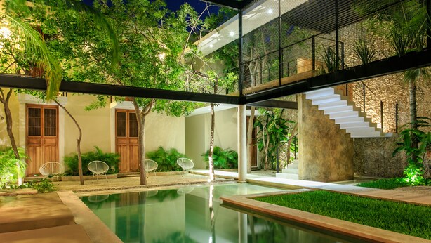 A modern outdoor pool area with a glass-enclosed staircase, wooden doors, and lush greenery. - Casa de Las Palomas by Palomas Hotels -  Adults only (Mérida)