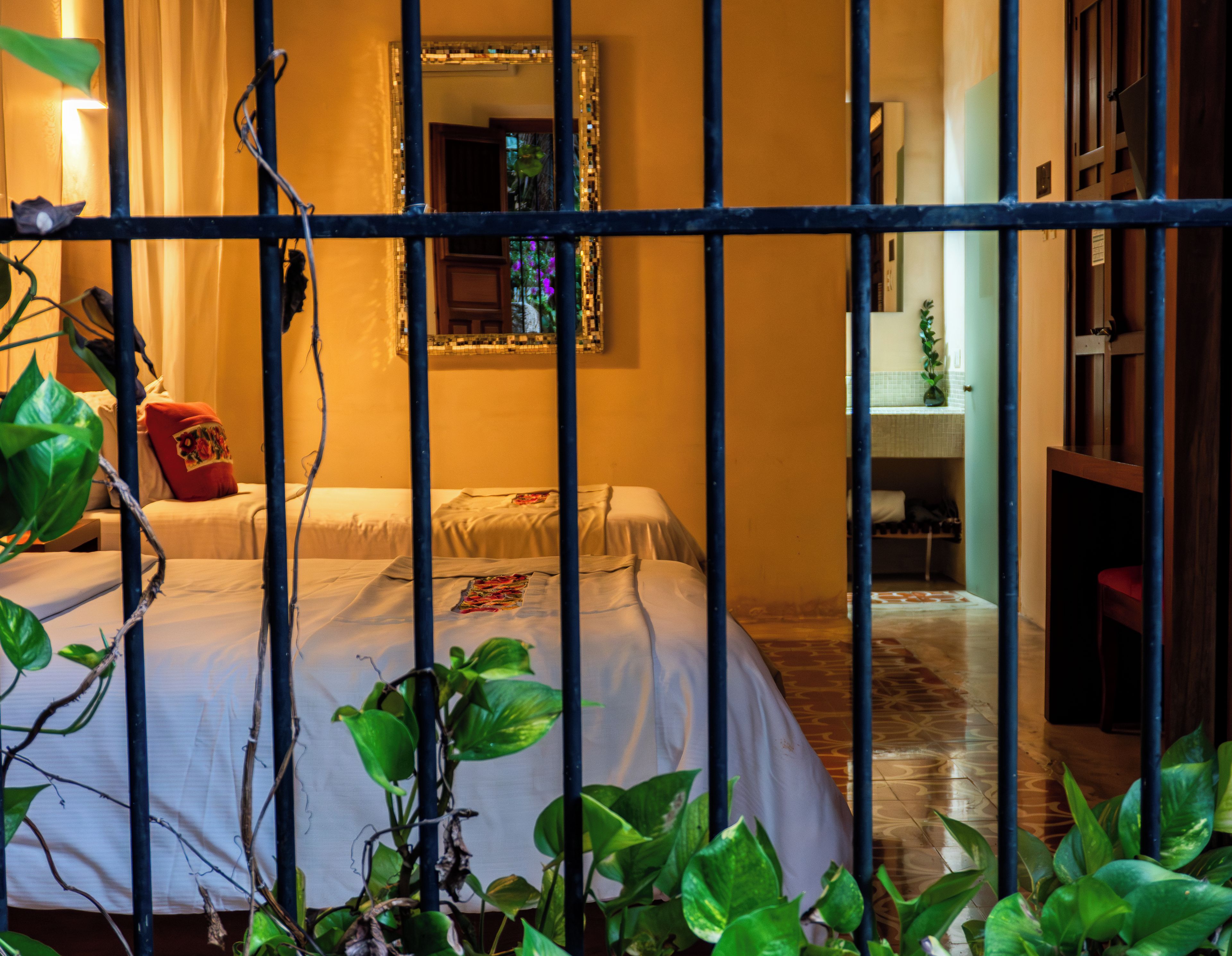 Una habitación con cama, espejo y vista al baño.