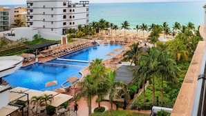A resort with a large pool, palm trees, and a view of the ocean. - Holiday Inn Club Vacations Grand Residences by IHG - All Inclusive (Puerto Morelos)