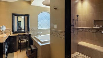 A bathroom with a sink, mirror, chair, and bathtub.