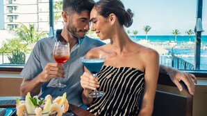A couple sitting at a table with a view of the beach and ocean. - Holiday Inn Club Vacations Grand Residences by IHG - All Inclusive (Puerto Morelos)