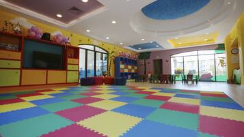 Children can play safely on the interlocking foam floor amidst colorful murals and a large window with an outside view.