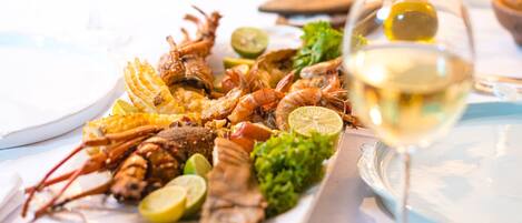 Un plato de mariscos con copas de vino sobre una mesa.