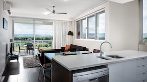A modern kitchen with a dining area, large windows, and a view of the outdoors. - Holborn at Central (Townsville)