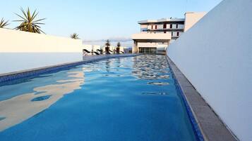 Swimmers can enjoy the pool surrounded by a low wall.