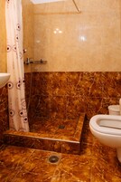 Un baño con ducha, inodoro y lavabo.