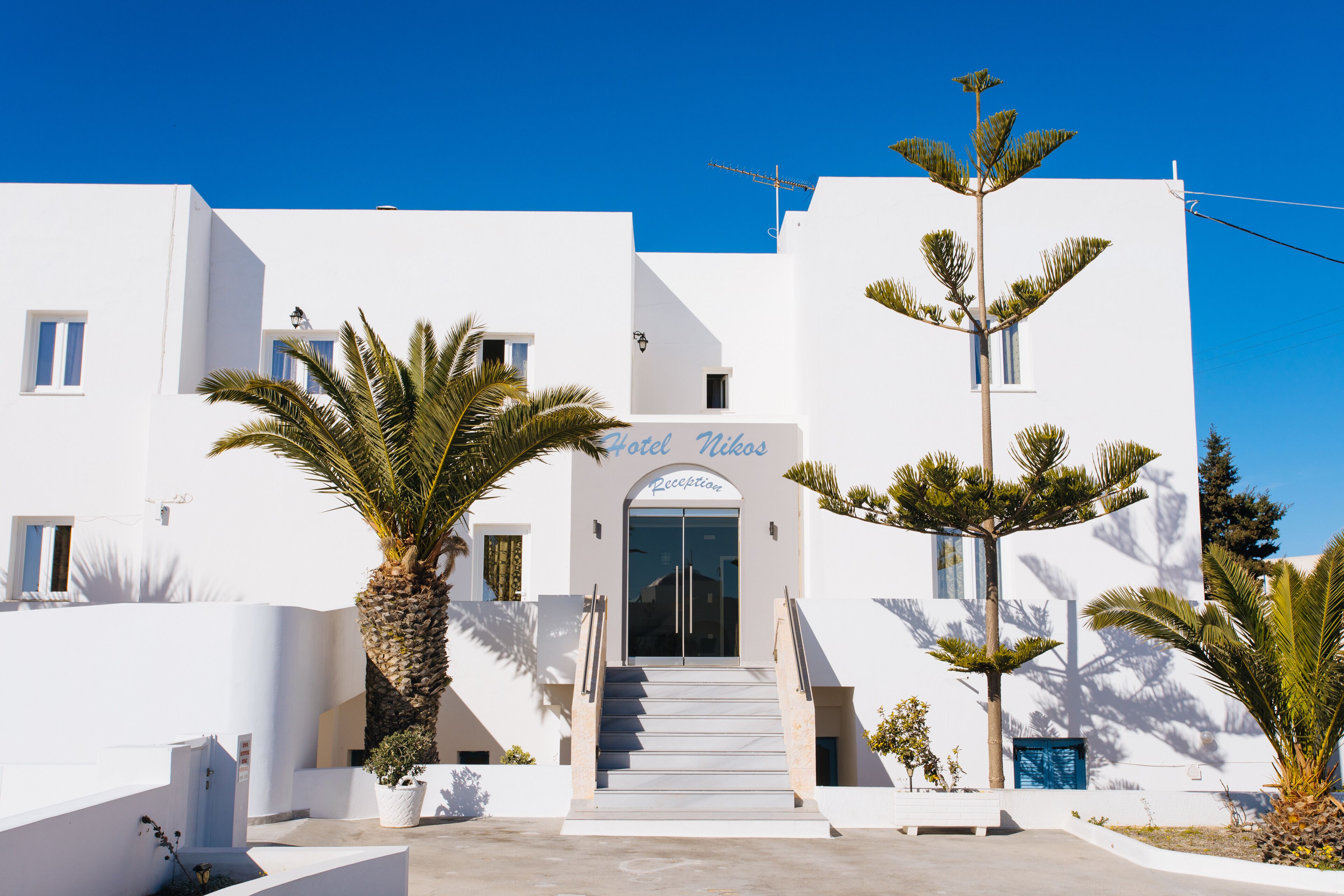 A white building with a sign reading "Hotel Vikas Reception."