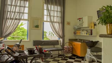 A room with a checkered floor, a bench, a sink, and a window with curtains.