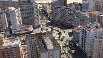 Paisagem costeira com edifícios altos, uma praia e vista clara do oceano.