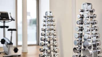 A gym with a wall of dumbbells arranged by weight.