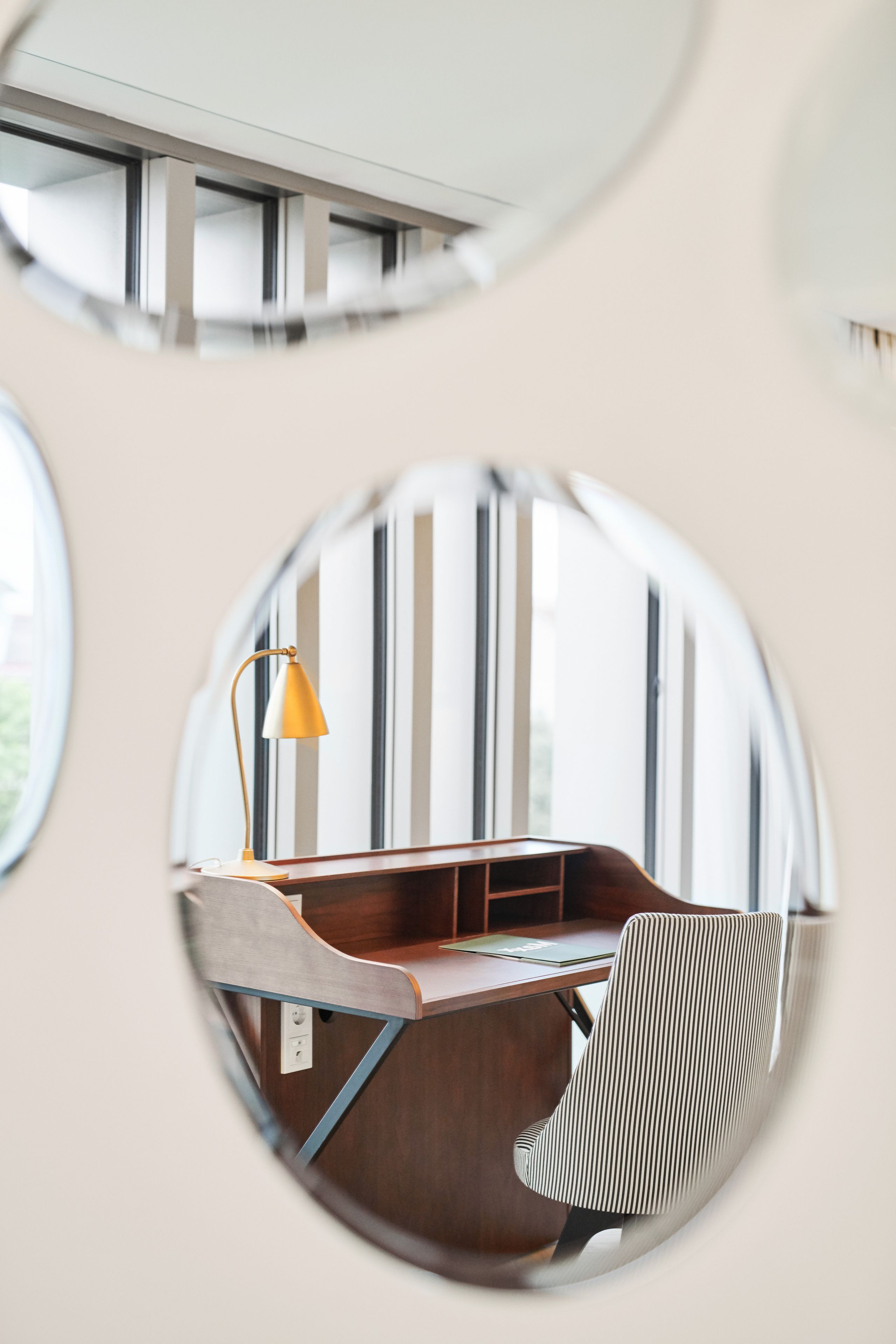 A modern office space with a desk, chair, and a lamp.