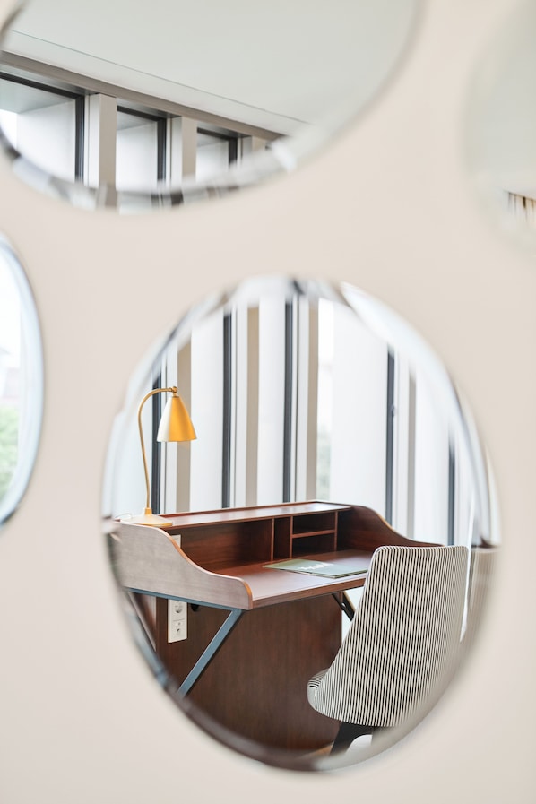 Un espacio de oficina moderno con un escritorio, una silla y una lámpara.