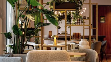 Un interior moderno con una mesa redonda, sillas y diversas plantas.