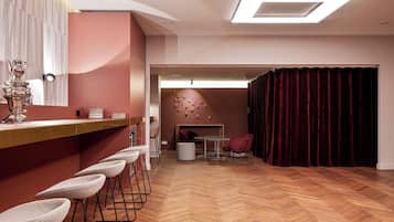 Un interior moderno con una zona de bar, asientos y un suelo de madera en patrón de espiga.