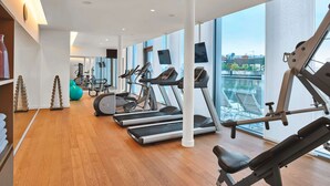 A modern gym with treadmills, elliptical machines, and free weights. Large windows offer views of the city. - MAXX by Steigenberger Vienna (Vienna)