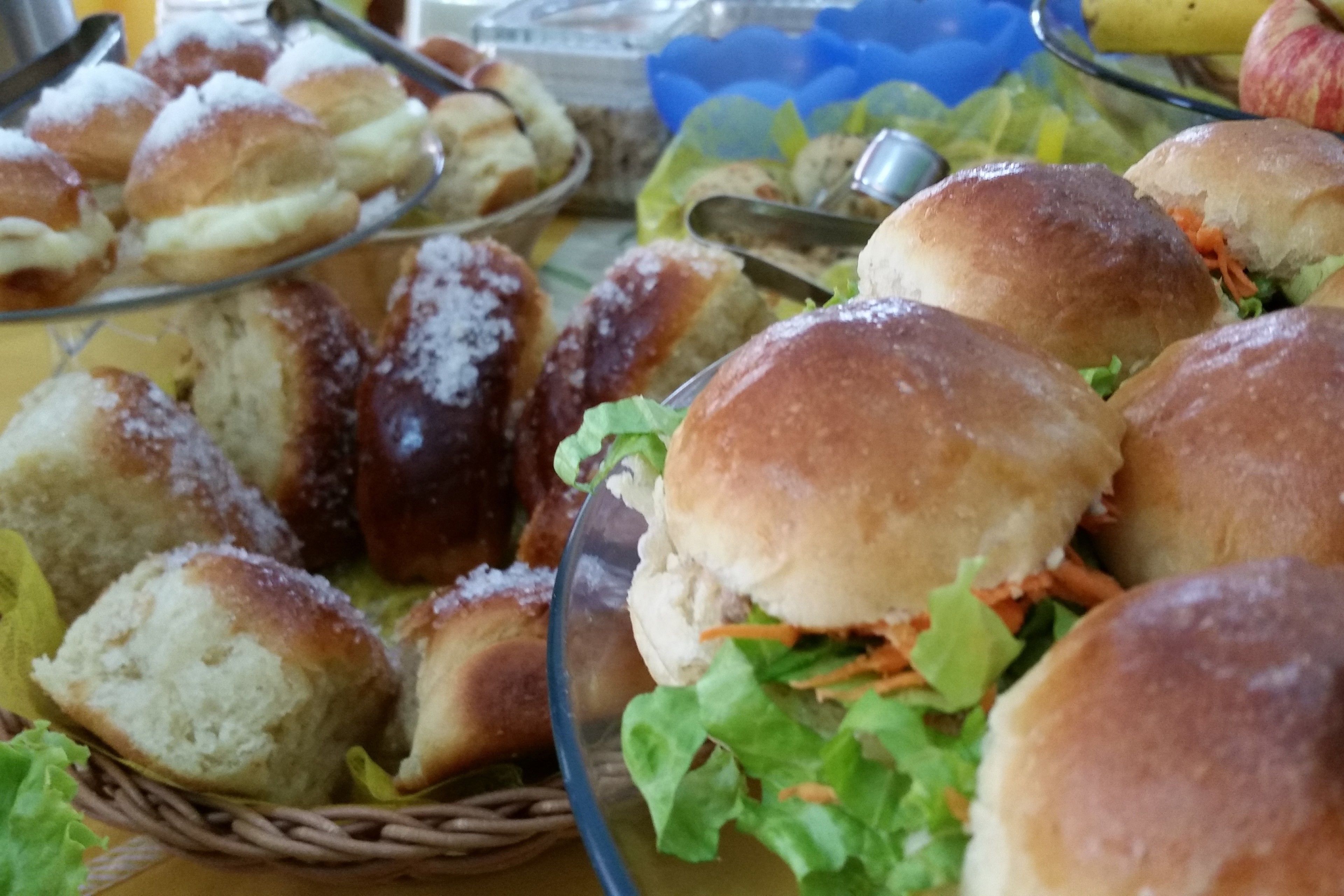 En buffet med forskellige slags brød og boller, herunder nogle med fyld.