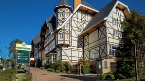 Un hotel de estilo europeo tradicional, con una entrada destacada, zona de recepción y un letrero que indica servicios como un restaurante.