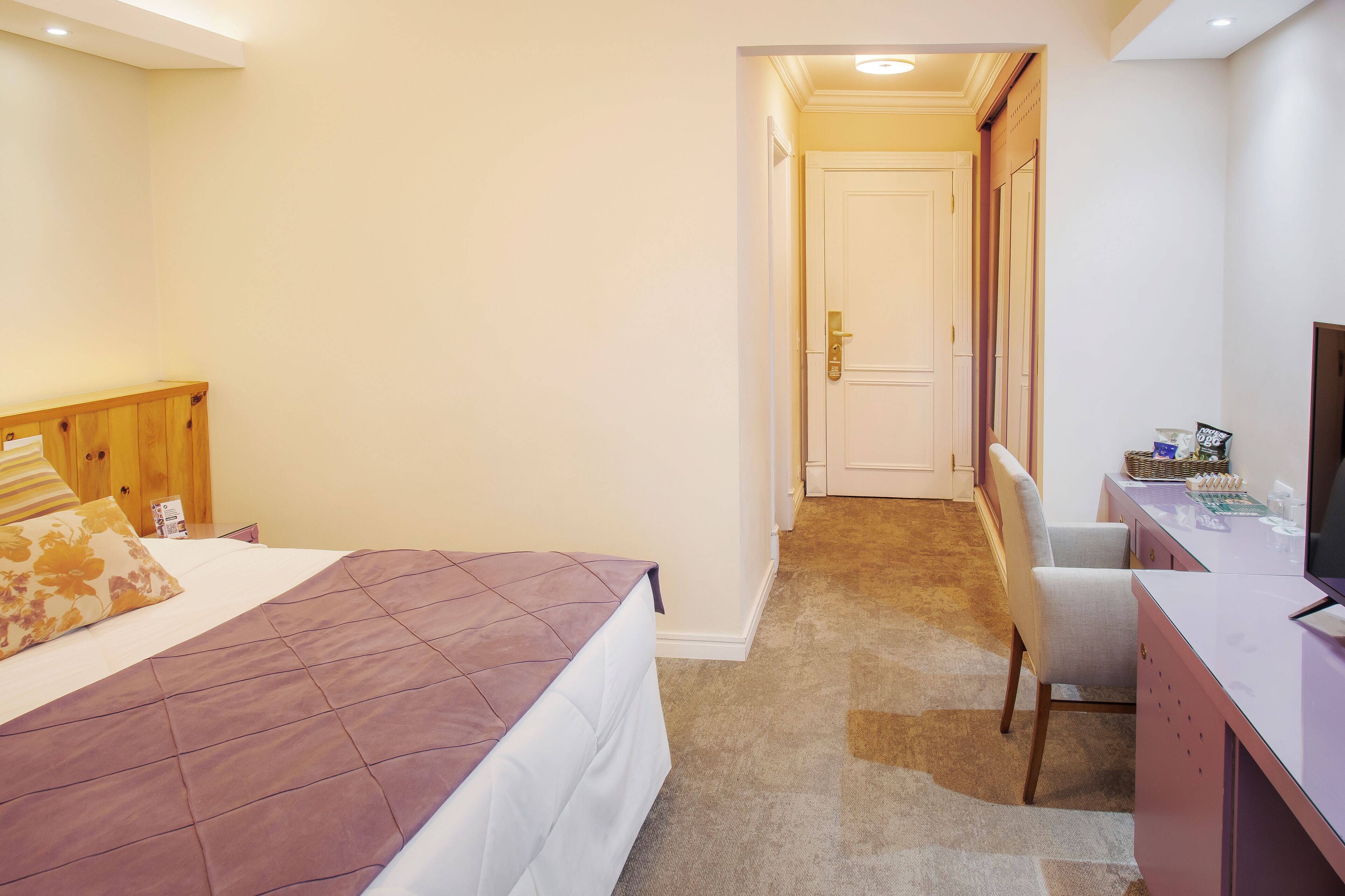 Ein Hotelzimmer mit Bett, Schreibtisch und Stuhl.