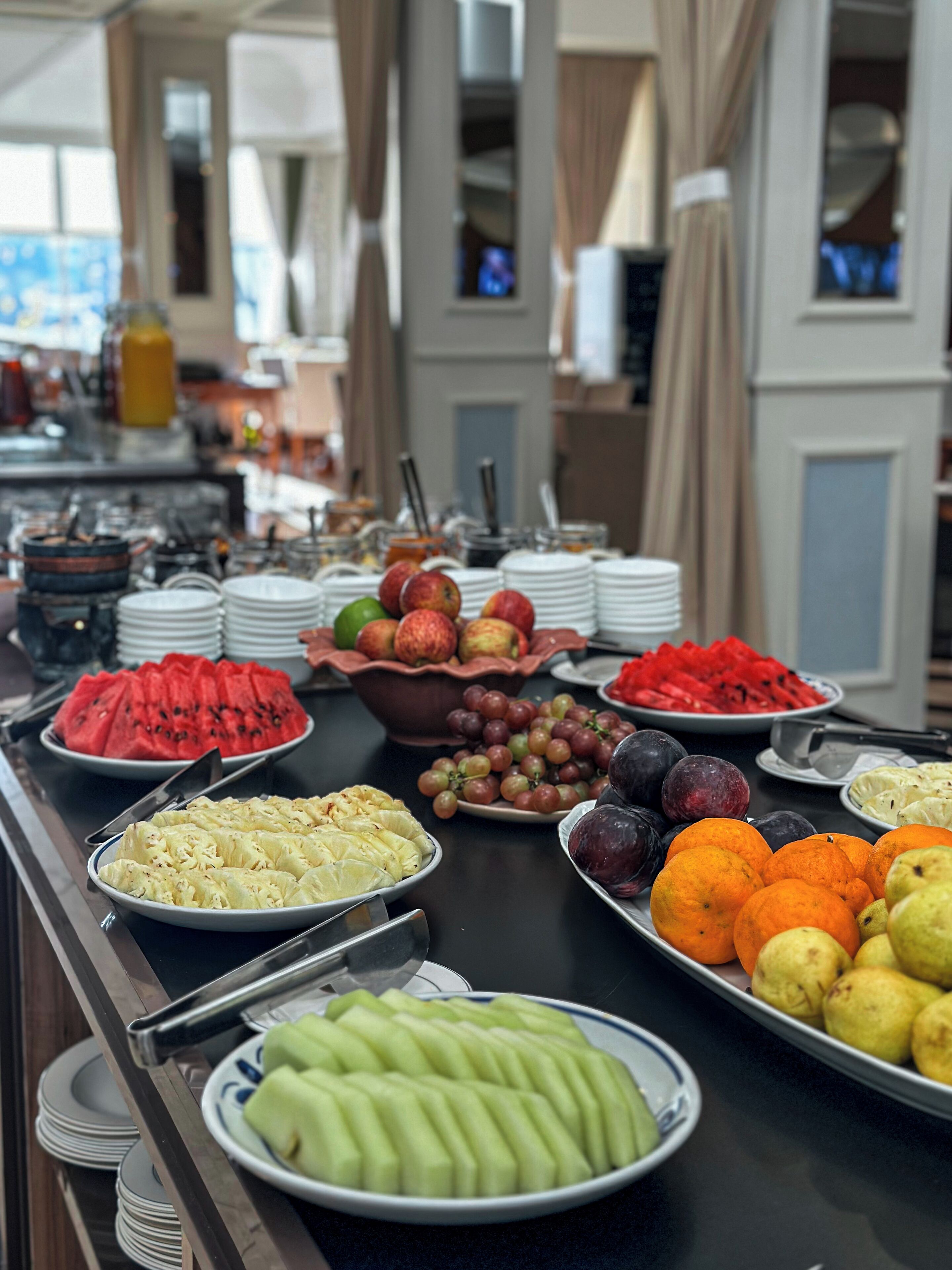 A buffet with various fruits and vegetables, including watermelon, grapes, and oranges.