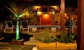 Alberca al aire libre, sombrillas en la alberca y camastros 