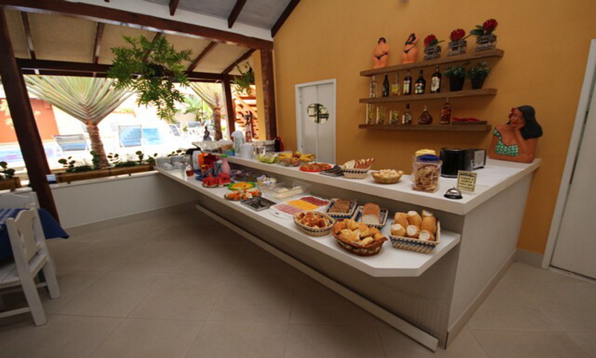 A buffet area with various food items and a tropical view.