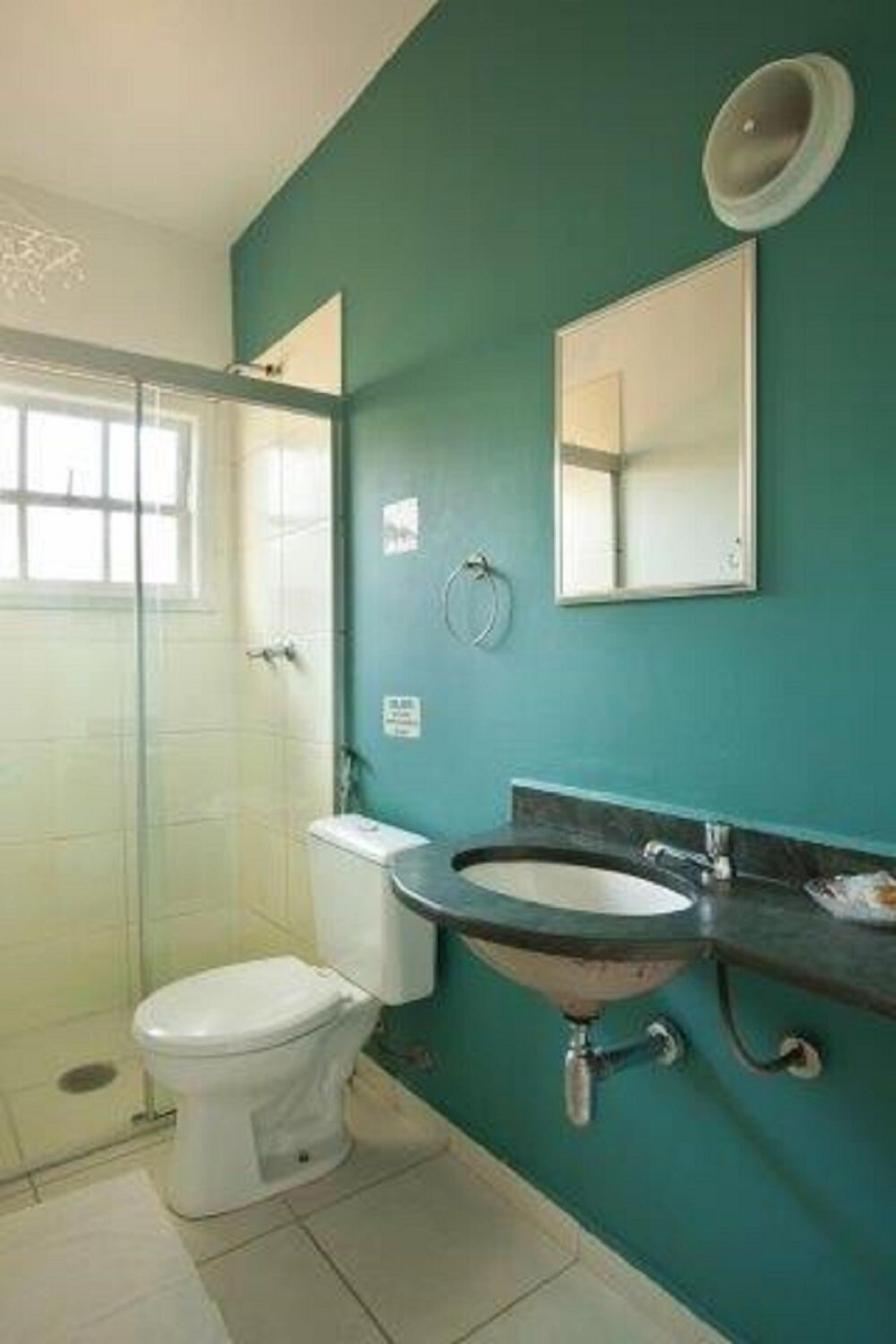 A bathroom with a toilet, sink, and a shower area.