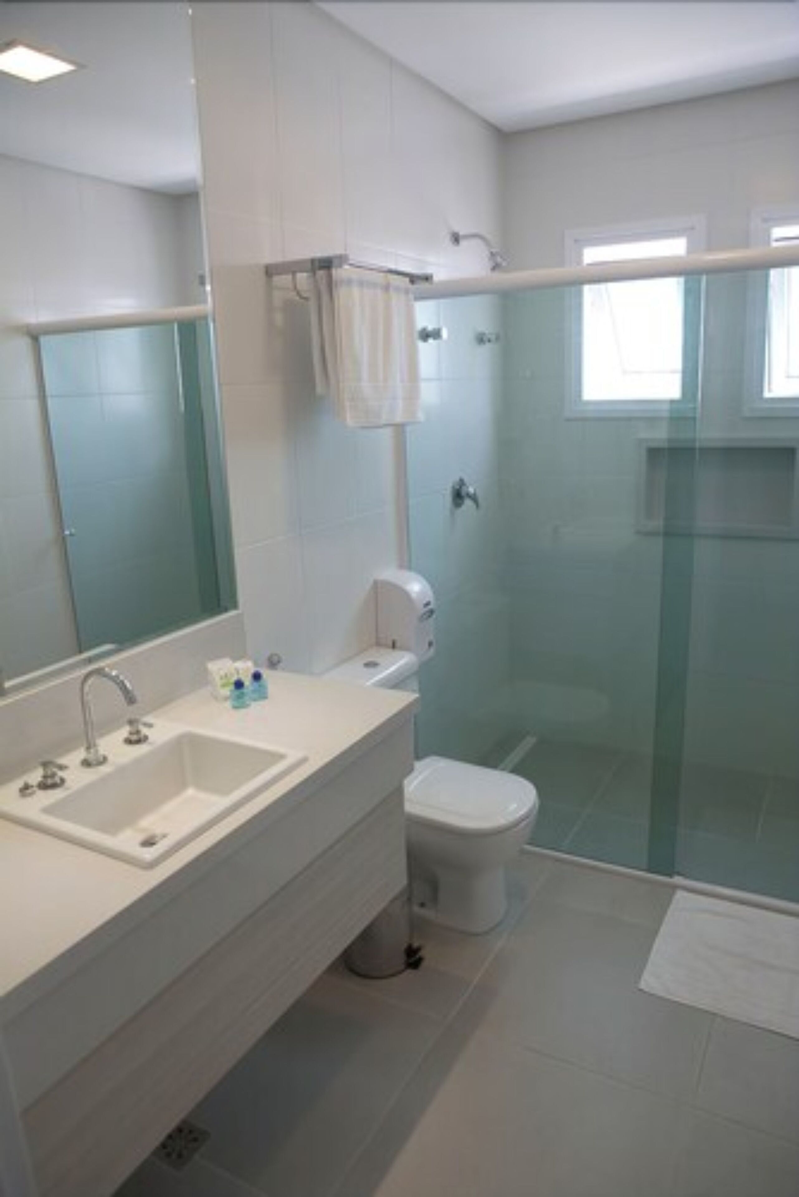 Ein modernes Badezimmer mit einer Duschkabine, einem weißen Waschbecken und einer Toilette.