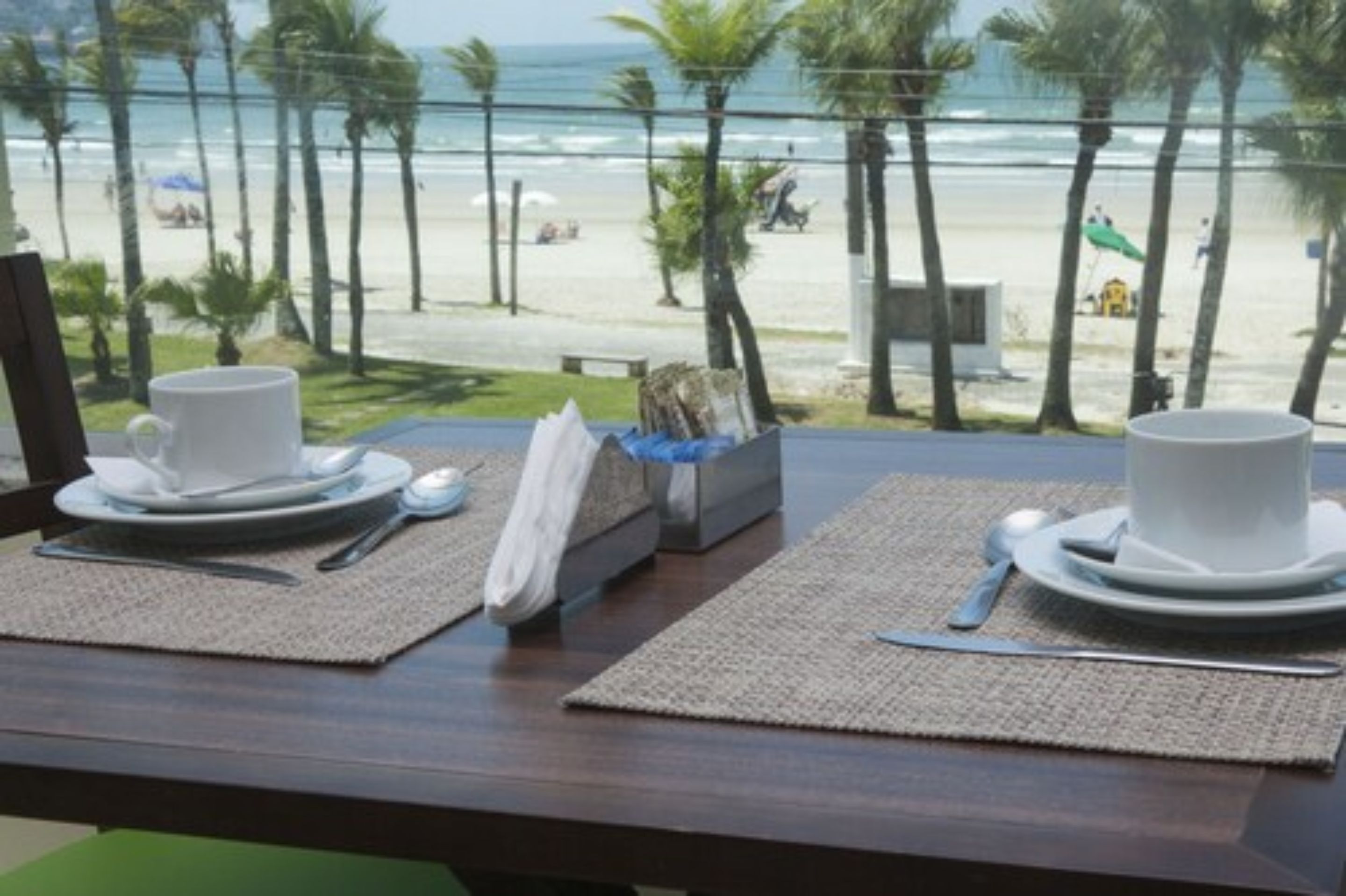 A table set for two with a view of the beach and ocean.