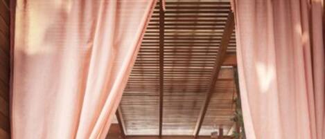 Interior acogedor de una cabaña de madera con una cama, una mesita y una silla.
