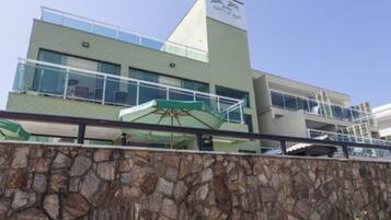 A modern building with a stone facade, a glass balcony, and a sign that reads "Hotel".
