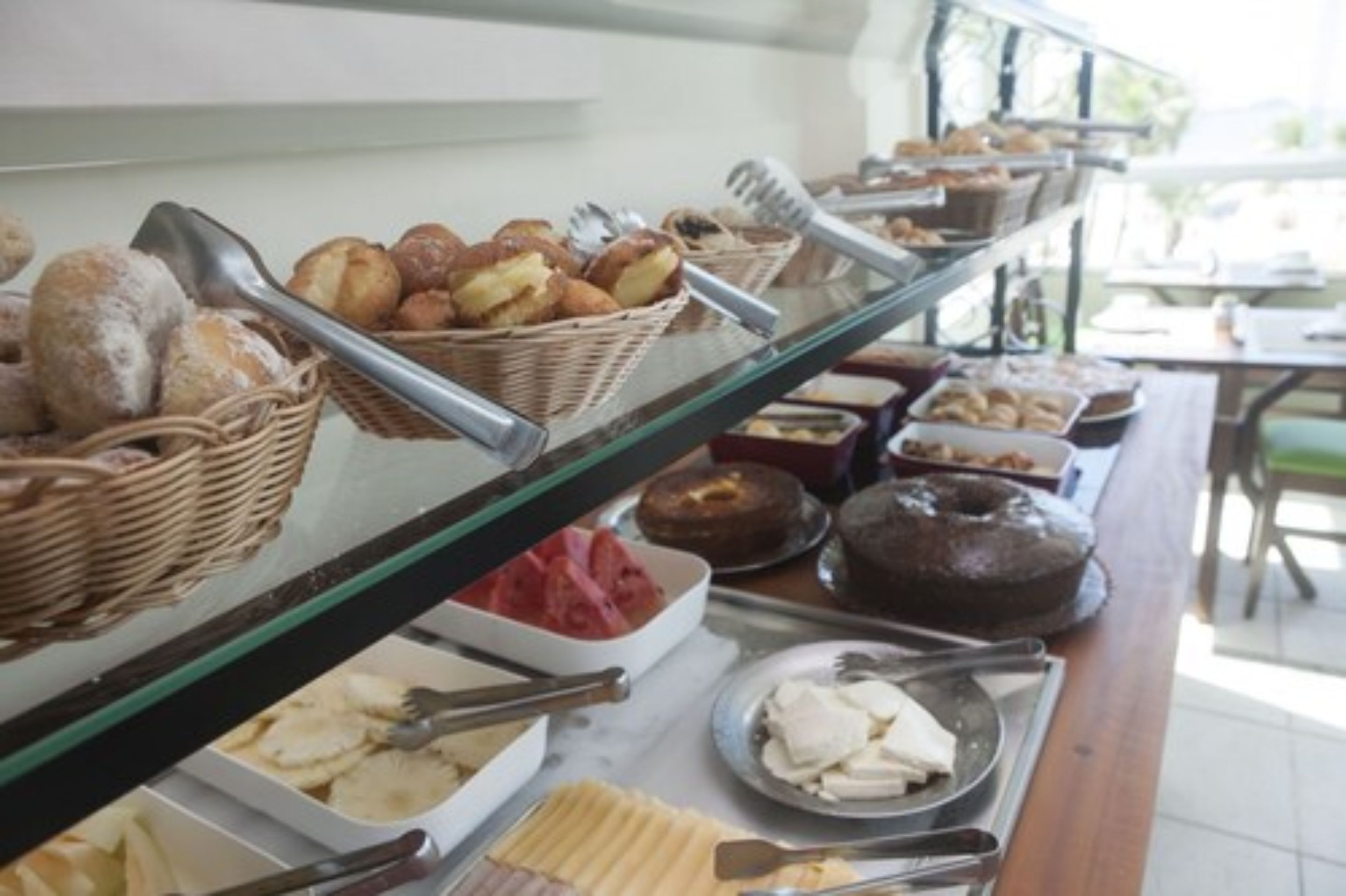 A buffet with various food items including bread, pastries, and cheese.