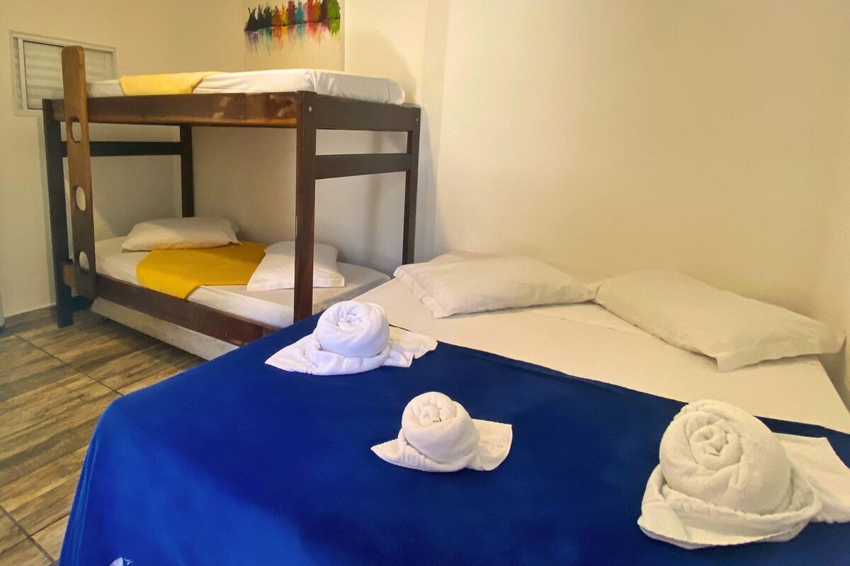 Ein Zimmer mit einem Etagenbett, einer blauen Bettdecke und zwei Handtüchern auf dem Bett.