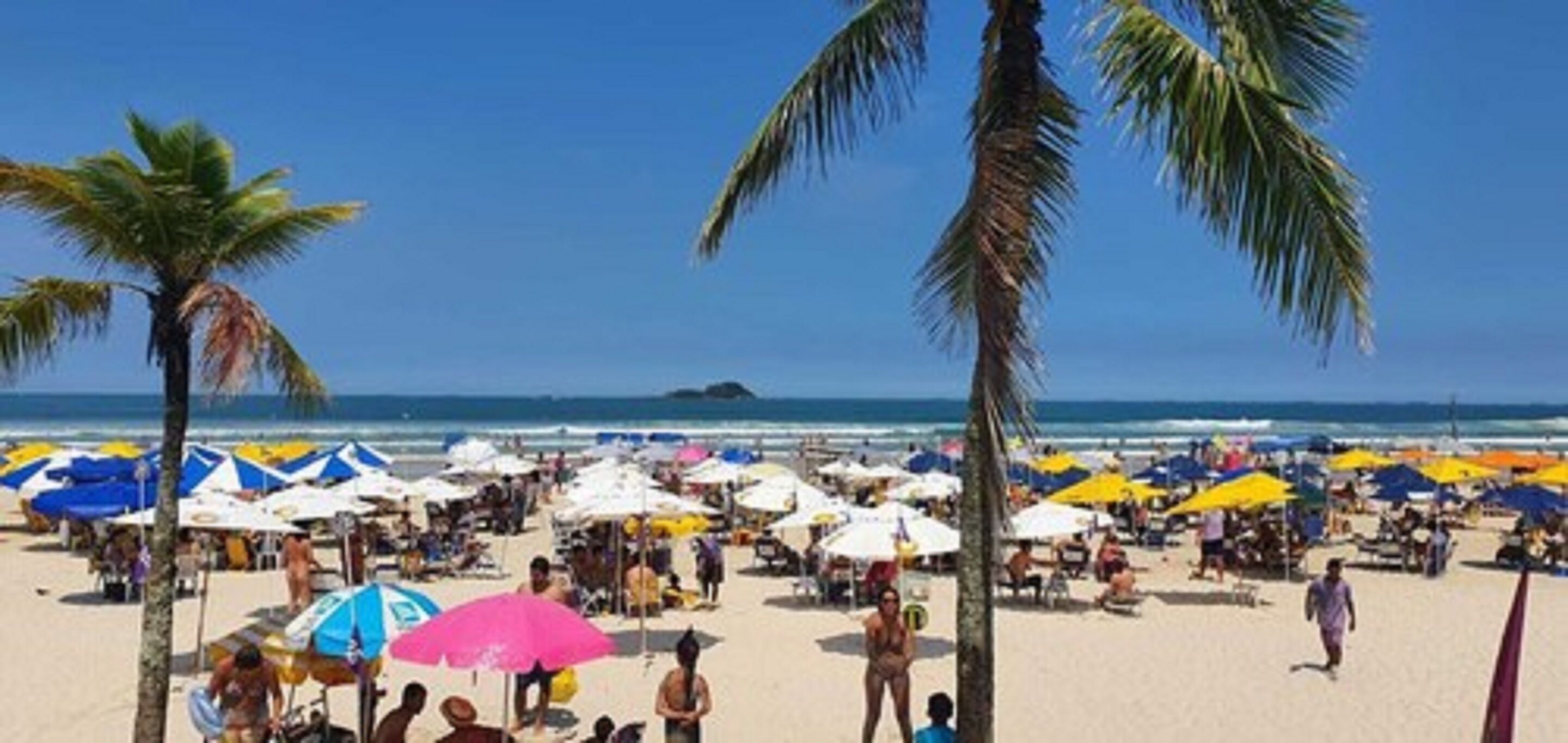 Perto da praia, areia branca, espreguiçadeiras, guarda-sóis 