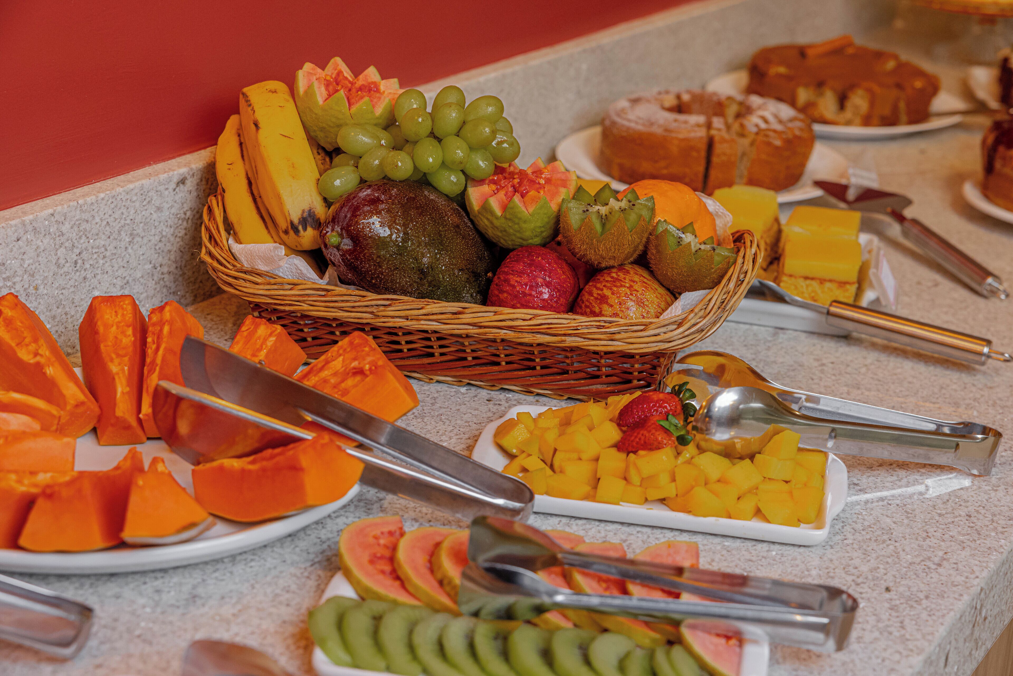 Una mesa de buffet con diversas frutas, verduras y pasteles.