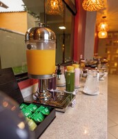 Eine Getränkestation mit einem großen Spender, einer Kaffeemaschine und verschiedenen Behältnissen.