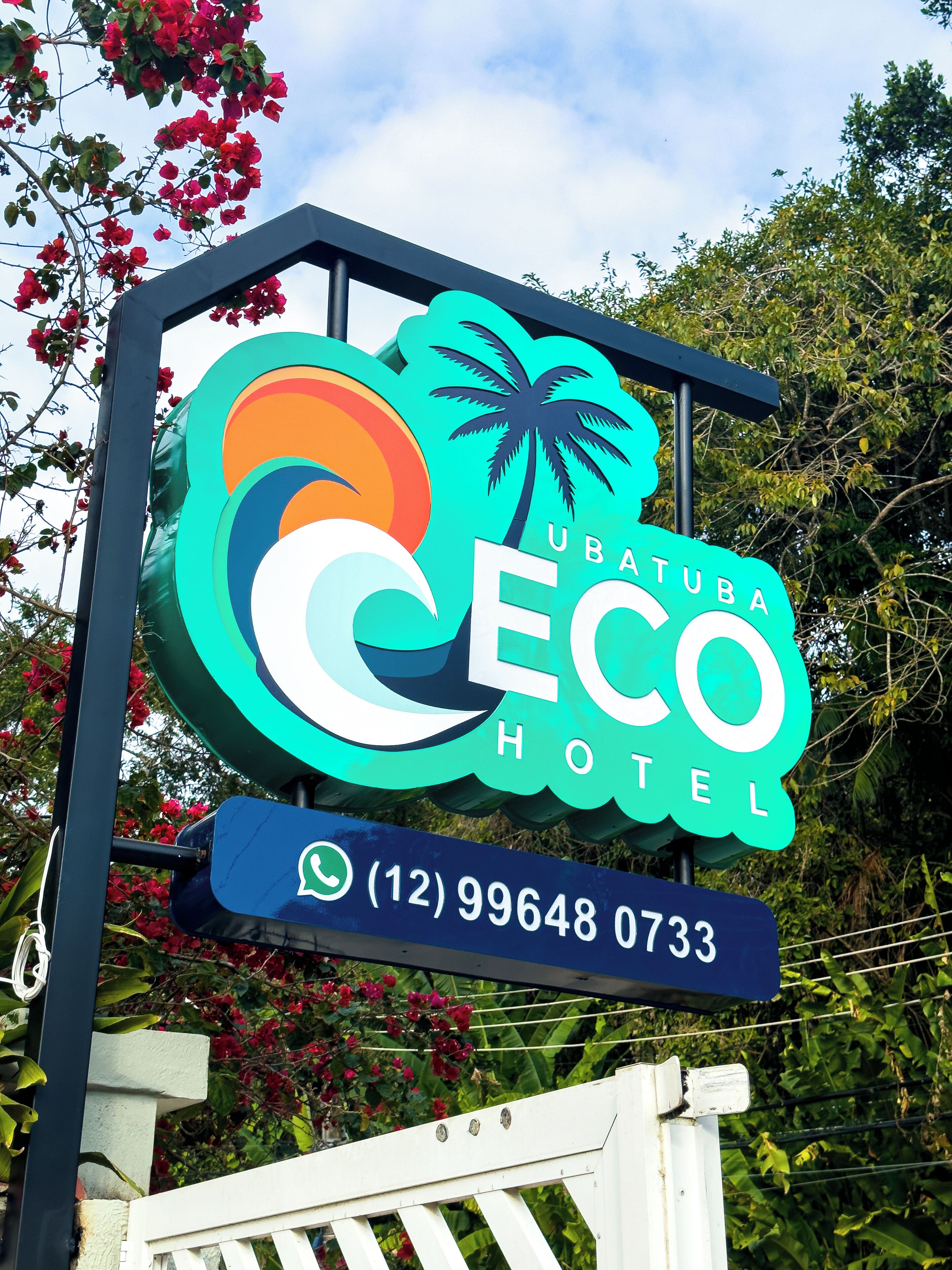A hotel sign with the name "Ubatuba Eco Hotel" and a contact number.