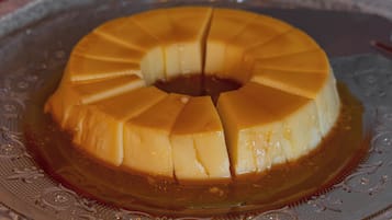 Eine Karamell-Quarktorte auf einer verzierten Glasplatte.