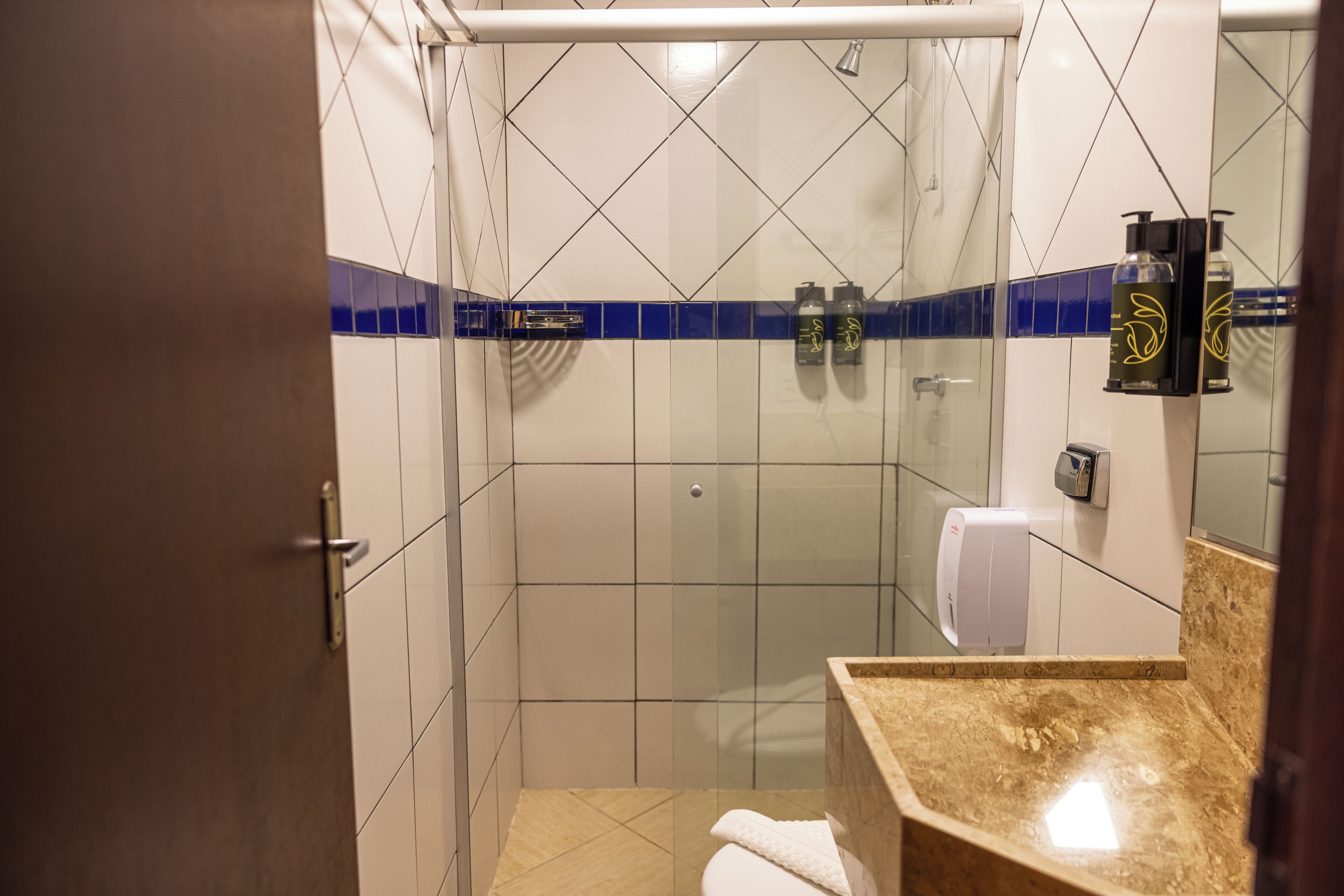 A bathroom with a shower, a toilet, and a sink.