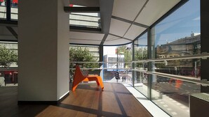 A modern interior with large windows, a wooden floor, and a curved railing.