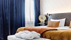 A hotel room with a large bed, a bedside table with a lamp, and a window with curtains. - Best Western Hotel Savoy (Karlstad)