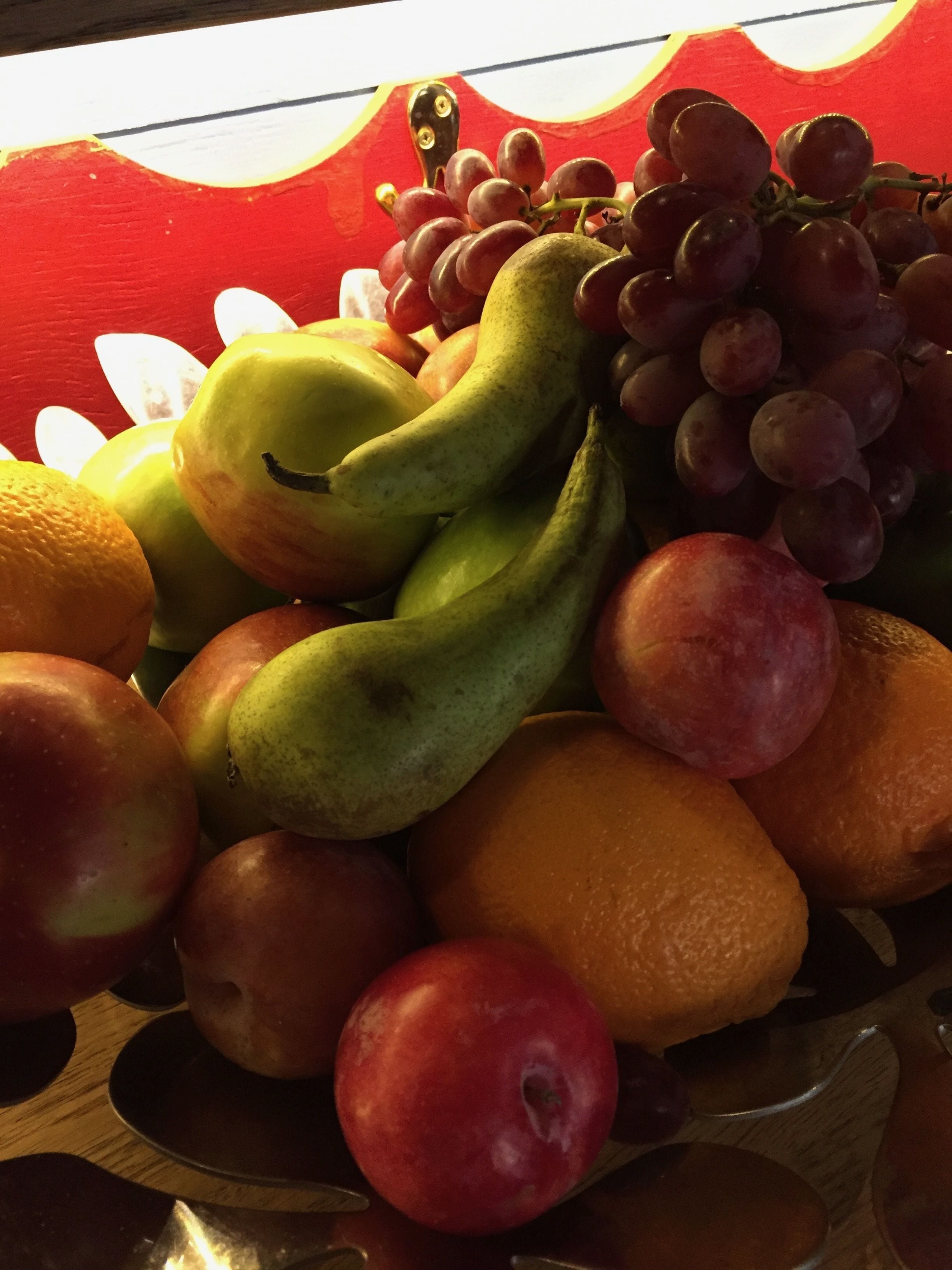 A variety of fruits including apples, oranges, bananas, and grapes arranged on a wooden surface.