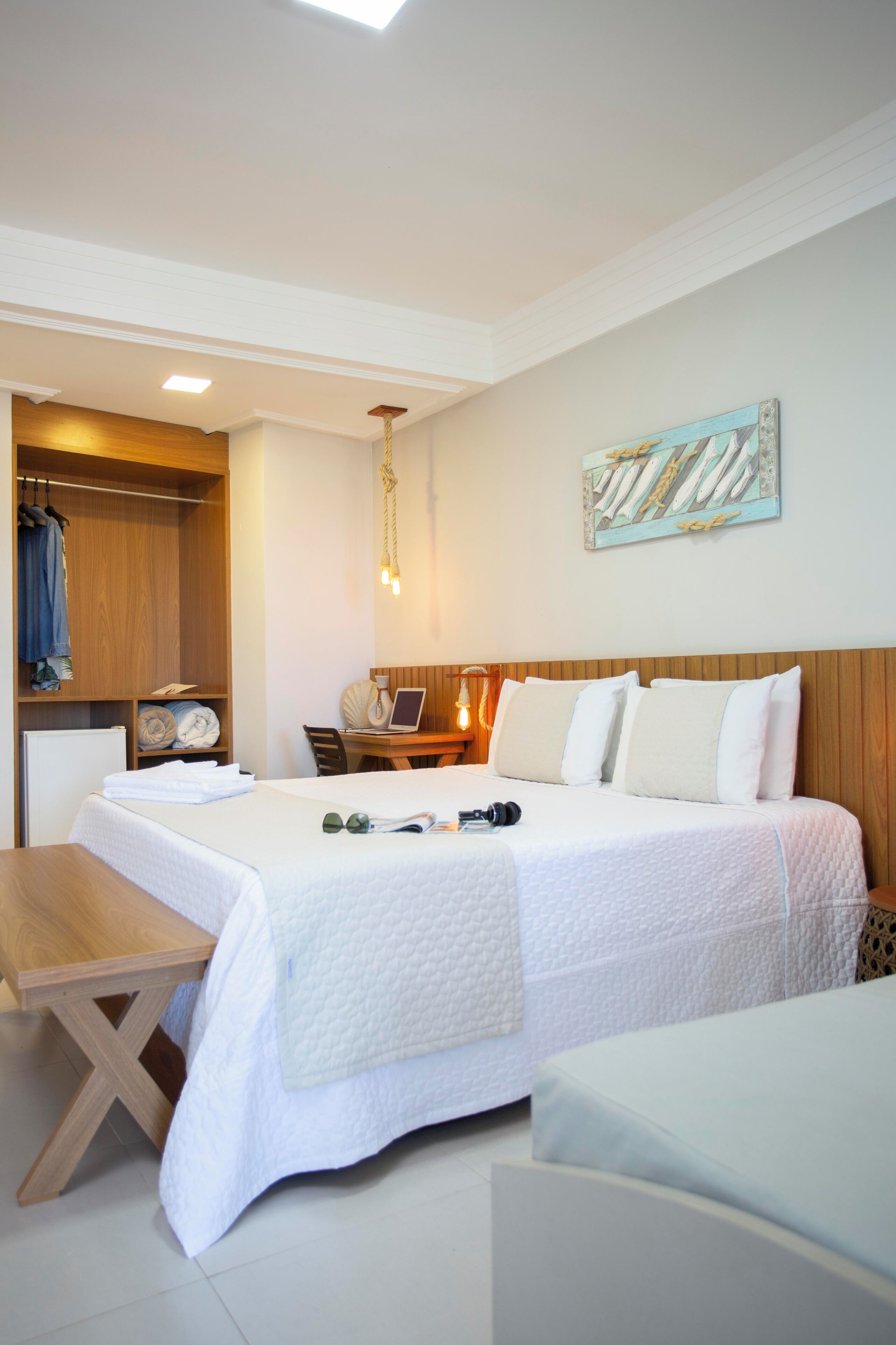 A hotel room with a bed, a desk, a chair, and a wardrobe.