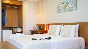 A hotel room with a bed, a desk, a chair, and a wardrobe.