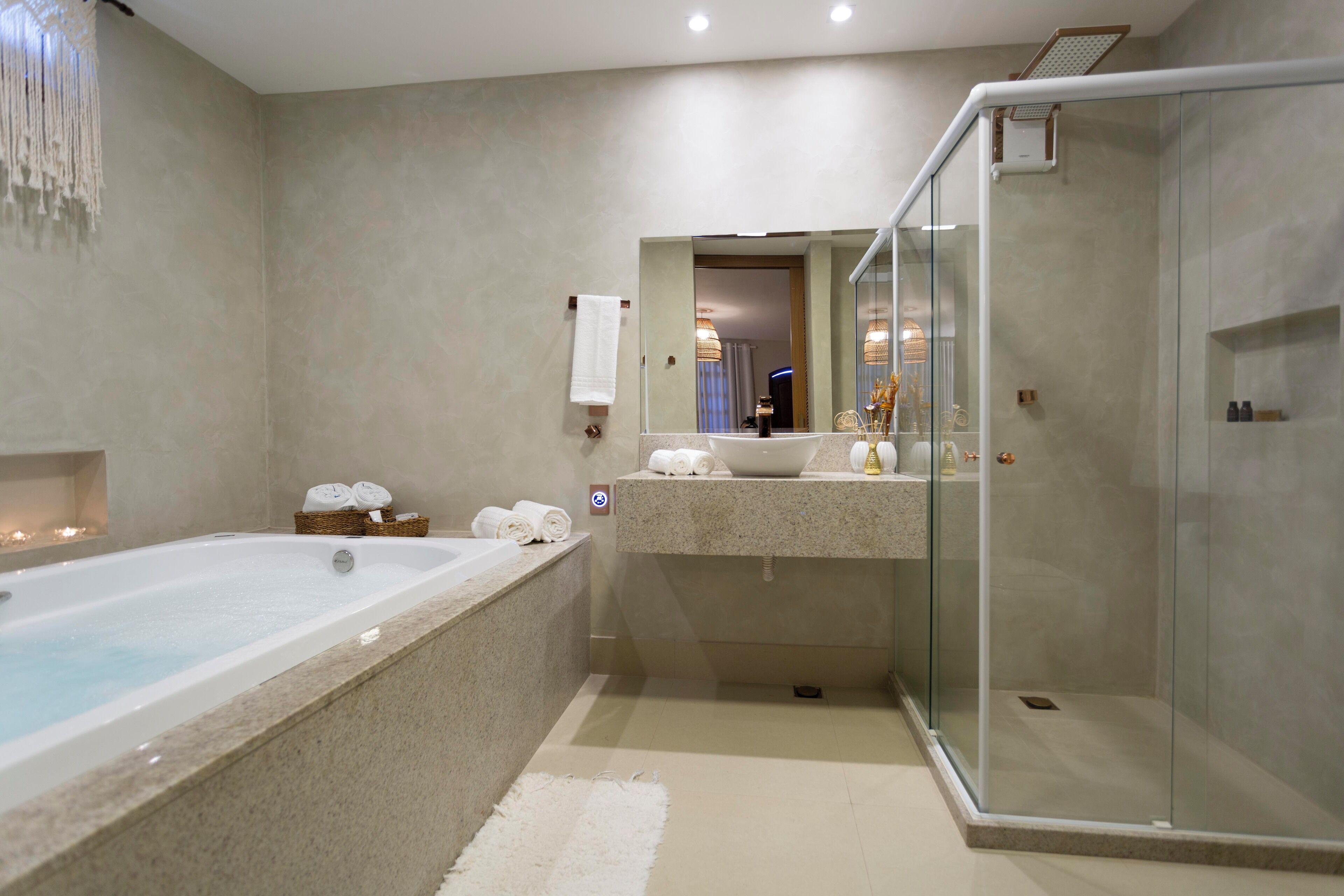 A modern bathroom with a bathtub, a glass-enclosed shower, and a vanity with a sink and mirror.